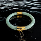 Green jade bracelet with gold accents on water