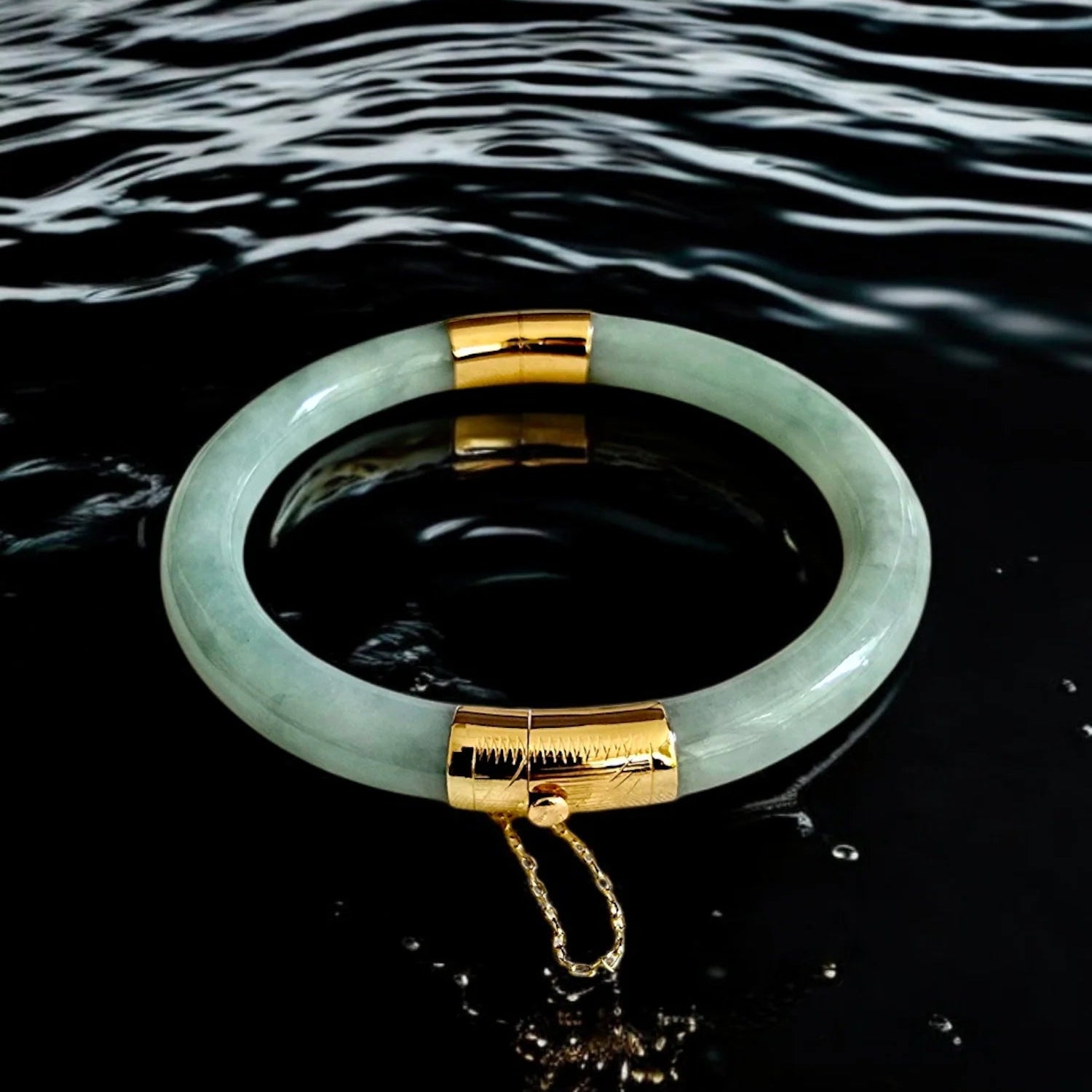 Green jade bracelet with gold accents on water