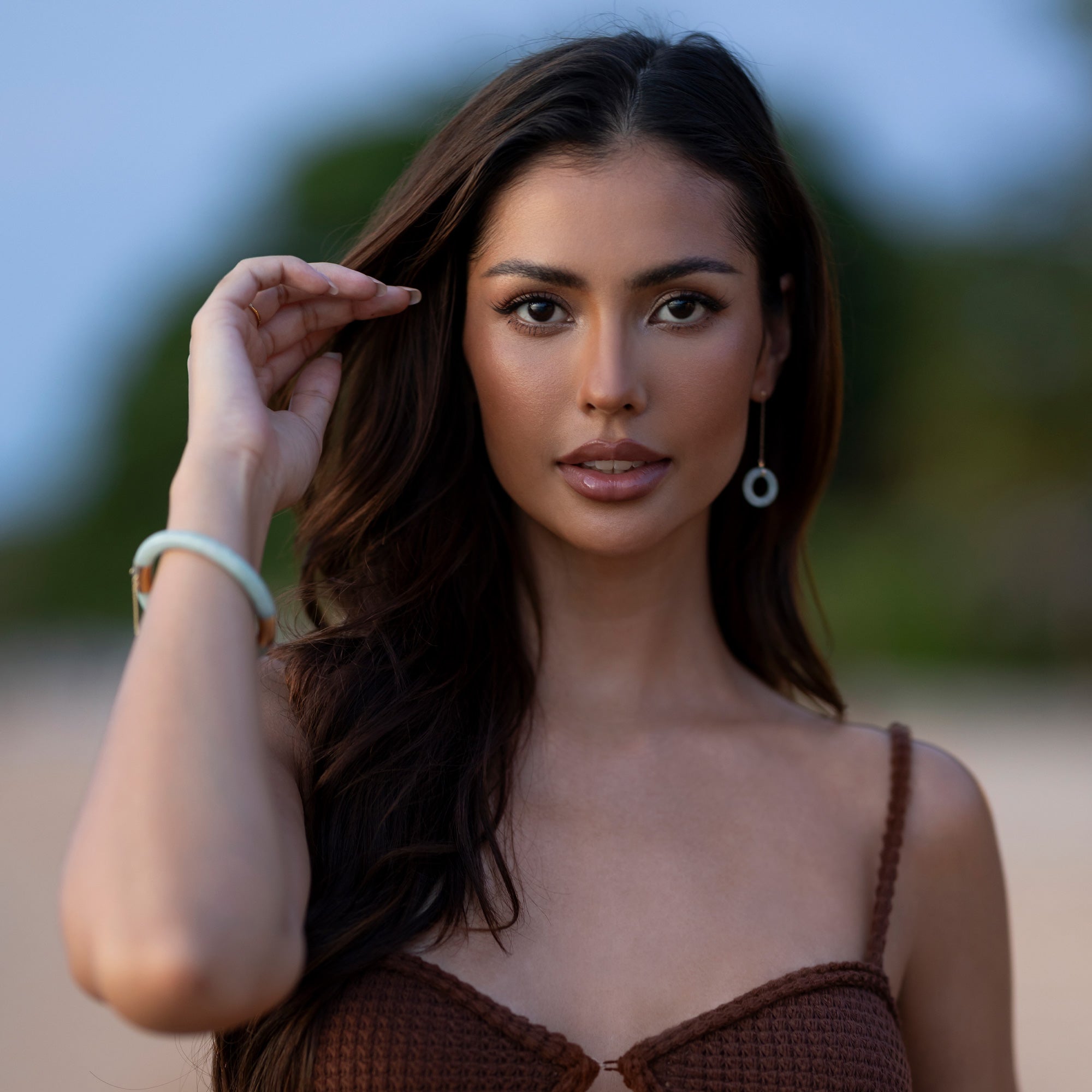 Model wearing a jade bangle and jade drop earrings