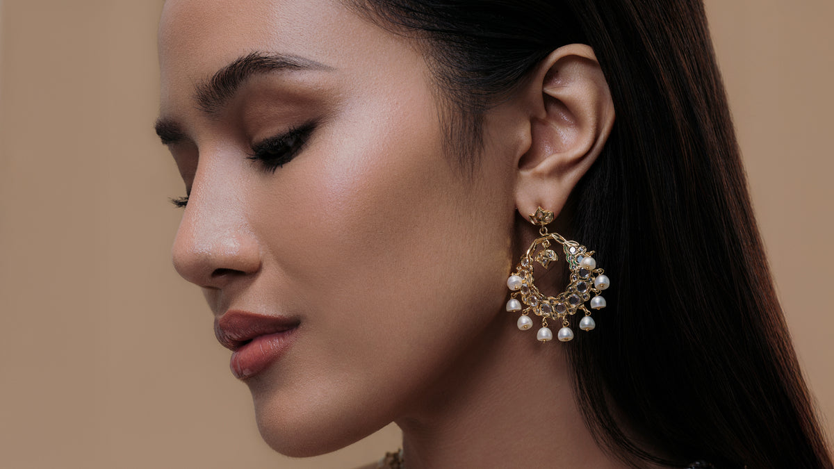 Profile of model wearing pearl-trimmed gold hoop earring