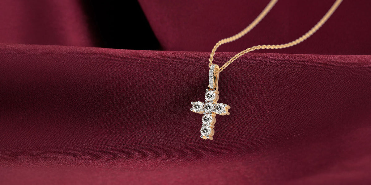 Gold diamond cross pendant on burgundy satin, banner crop